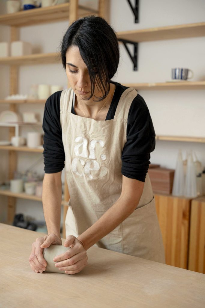 Sara Varo amasa un trozo de barro sobre la mesa del taller de cerámica