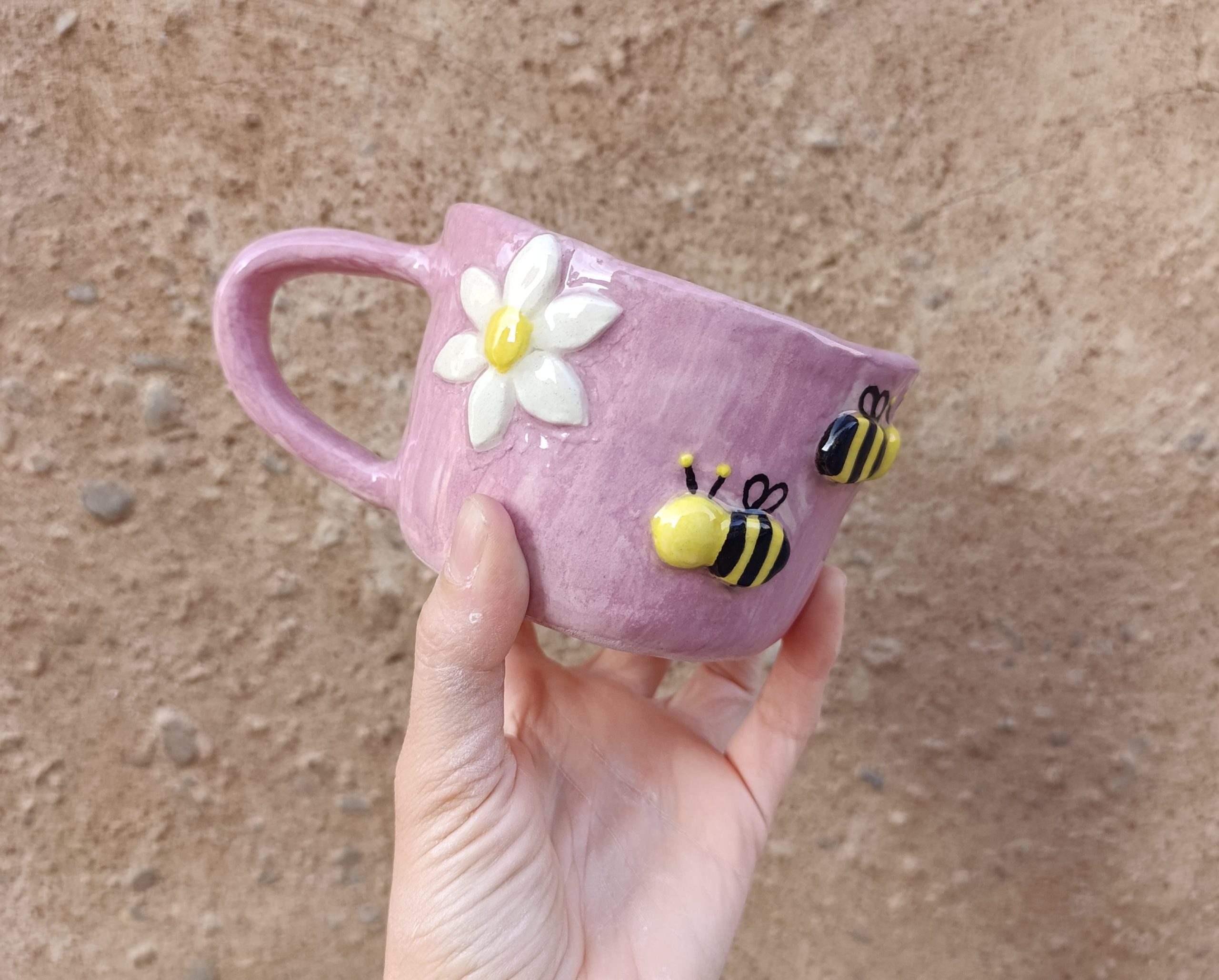 Taza de cerámica lila con una margarita y una abeja en relieve, hecha a mano